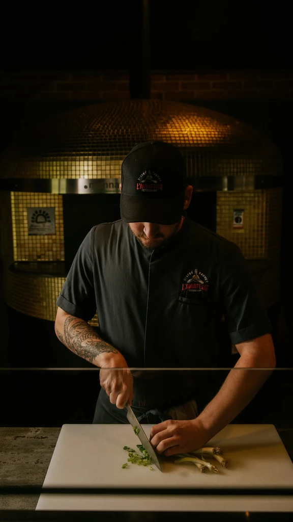 Busy pizzeria with wood-fired oven and customers dining